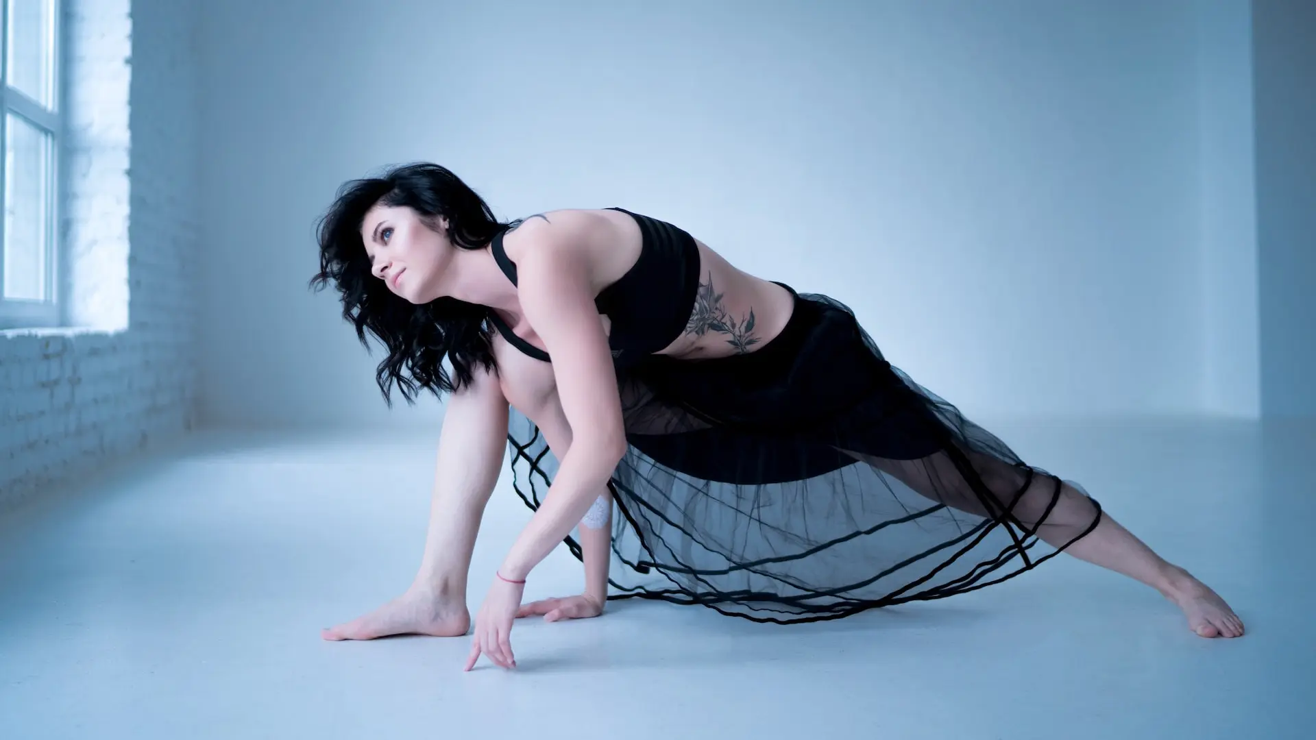woman in black tank top and black and white skirt lying on blue floor